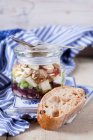 Beetroot with goat's cheese, apple, walnuts, olives and onions in glass jar — Stock Photo