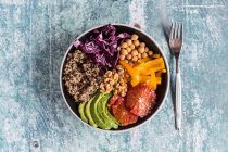Ciotola di verdure con quinoa, ceci, avocado, peperoni, cavolo rosso e arance rosse — Foto stock