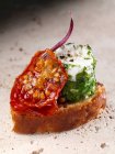 Hierba barrelled queso de cabras en un croute de oliva verde y especias de tomate canapé editorial de alimentos - foto de stock
