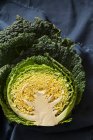 Savoy cabbage cut in half showing the cross section on blue fabric — Stock Photo
