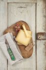 Hard cheese on a wooden board with grapes and a knife — Stock Photo