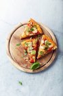 Fette di pizza con porro e aglio su un tagliere — Foto stock