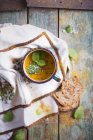 Sopa cremosa de cenoura em uma caneca de esmalte; decorado com hortelã fresca e flocos de sal marinho — Fotografia de Stock