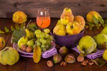 Натюрморт з осінніми фруктами, соком айви та волоськими горіхами — стокове фото