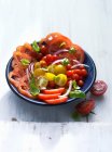Ensalada de tomate hecha con tomates de diferentes tamaños - foto de stock