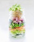 Vegetable salad with apple, edamame, herring and shoots in a glass jar — Stock Photo