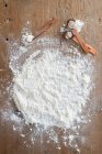 A flour-covered wooden board with flour with measuring spoons — Stock Photo