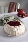 Pavlova-Kuchen mit Granatapfelkernen auf Teller — Stockfoto