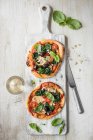 Mini goats cheese and spinach pizza with pine nuts, view from above — Stock Photo