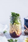Шаруватий салат з кіокою та овочами у скляній банці — стокове фото