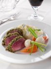 A plate of lamb loin in a herb crust with vegetables — Stock Photo
