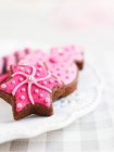 Chocolate Christmas biscuits with pink icing — Stock Photo