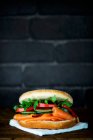 Un bagel con salmón ahumado, pepino, tomate y cohete - foto de stock