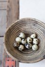 Quail eggs in wooden bowl, top view — Stock Photo