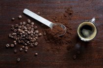 Granos de café, café molido y un espresso - foto de stock