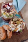 Буряк з козячим сиром, яблуком, волоськими горіхами, оливками та цибулею у скляній банці — стокове фото