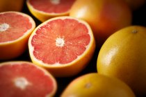 Грейпфруты, цельные и наполовину, крупным планом — стоковое фото