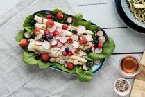 Salada de espargos com rabanetes, bagas e espinafre — Fotografia de Stock