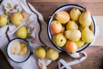 Pears in an enamel bowl on a wooden table — Stock Photo