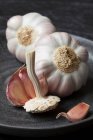 Garlic and cloves on wooden background — Stock Photo