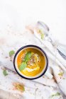 Zuppa di zucca in una tazza di smalto; decorata con basilico fresco e semi di girasole — Foto stock