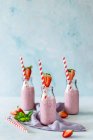 Delicioso batido con fresa fresca madura en la mesa en luz rosa - foto de stock