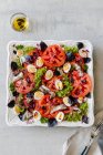 Salad with anchovies, quail eggs, tomatoes and basil — Stock Photo