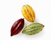 Fruits de cacao jaunes, rouges et verts sur fond blanc — Photo de stock