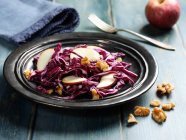 Red cabbage salad with apples wedges and pieces of nuts — Stock Photo