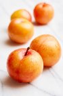 Yellow plums on a white marble plate — Stock Photo