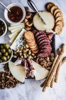 Cheese and salami board with crackers and olives — Stock Photo