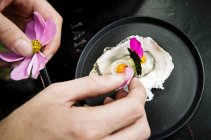 An oyster being decorated with flower petals — Stock Photo