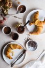 Petit déjeuner avec croissants, cacao, tartinade de noisettes et noix de cacao — Photo de stock