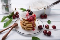Pancakes with vanilla ice cream, cherry jam and cherries — Stock Photo