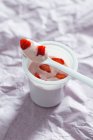 Yogurt en maceta de plástico con fresas frescas - foto de stock