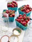 Fresh strawberries and jars — Stock Photo