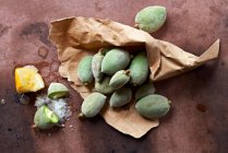 Green almonds in a paper bag — Stock Photo