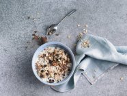 Bowl of chocolate muesli with yoghurt on stone surface — Stock Photo