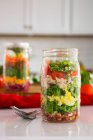 Salade en couches dans un verre aux épinards, haricots, fromage et oeuf — Photo de stock