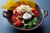Tomato and bean stew with couscous and sour cream — Stock Photo