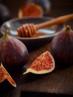 Fresh figs and a honey dipper on a dark wooden background — Stock Photo