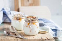 Yogurt with orange pieces and chopped nuts — Stock Photo