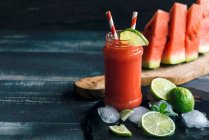 Watermelon juice in a glass with limes — Stock Photo