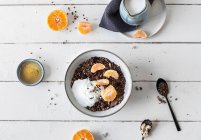 Шоколадні муслі з йогуртом та мандаринами в мисці — стокове фото