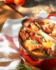 Chicken with bacon strips, tomatoes and tarragon in a casserole dish — Stock Photo