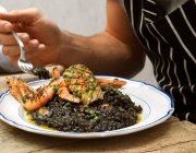 Squid ink risotto with seafood — Stock Photo