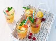 Fruity iced tea with mint on white basket tray — Stock Photo