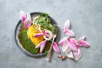 Ensalada de aguacate con flores de mango y magnolia - foto de stock
