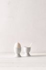 Huevo blanco en taza de huevo - foto de stock
