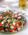 Ensalada de verano con judías verdes, jamón, pimientos y maíz - foto de stock